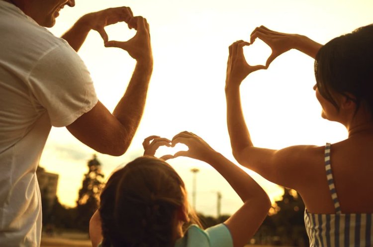 family making heart shape with hands